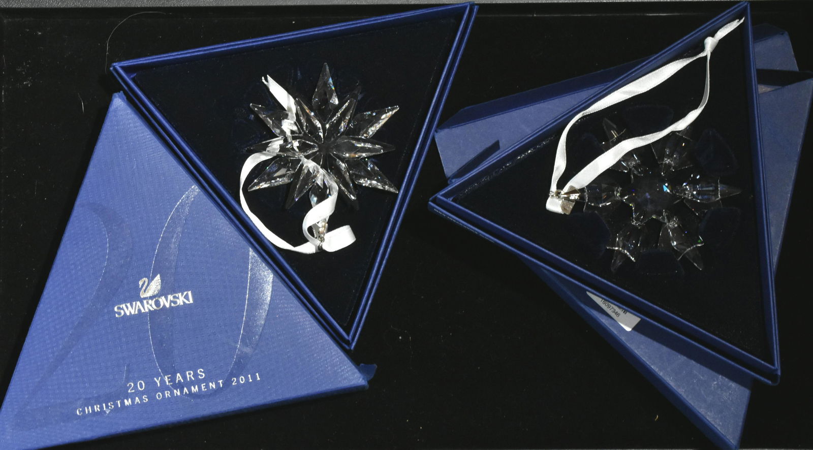 Two Swarovski Christmas Ornaments: A 2010 crystal snowflake and a 20th anniversary 2011 crystal ornament, Both with boxes.
