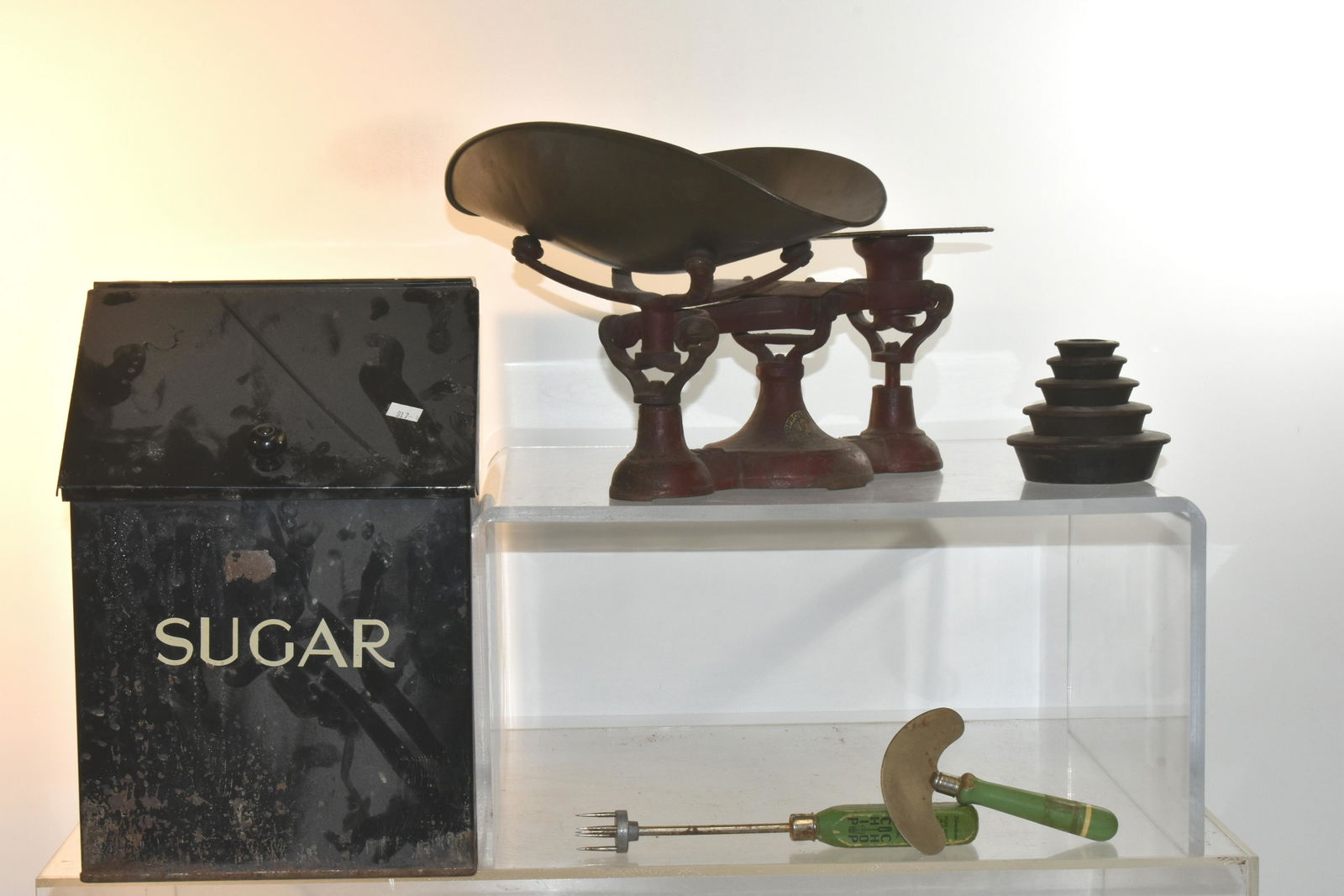 General Store Scale and a Sugar Box: Lot includes a vintage cast scale with weights (approx 8.5" H, 13" L, 12" W), a tin sugar box (approx 13"H x 9"x9"), and (2) green handled kitchen utensils.