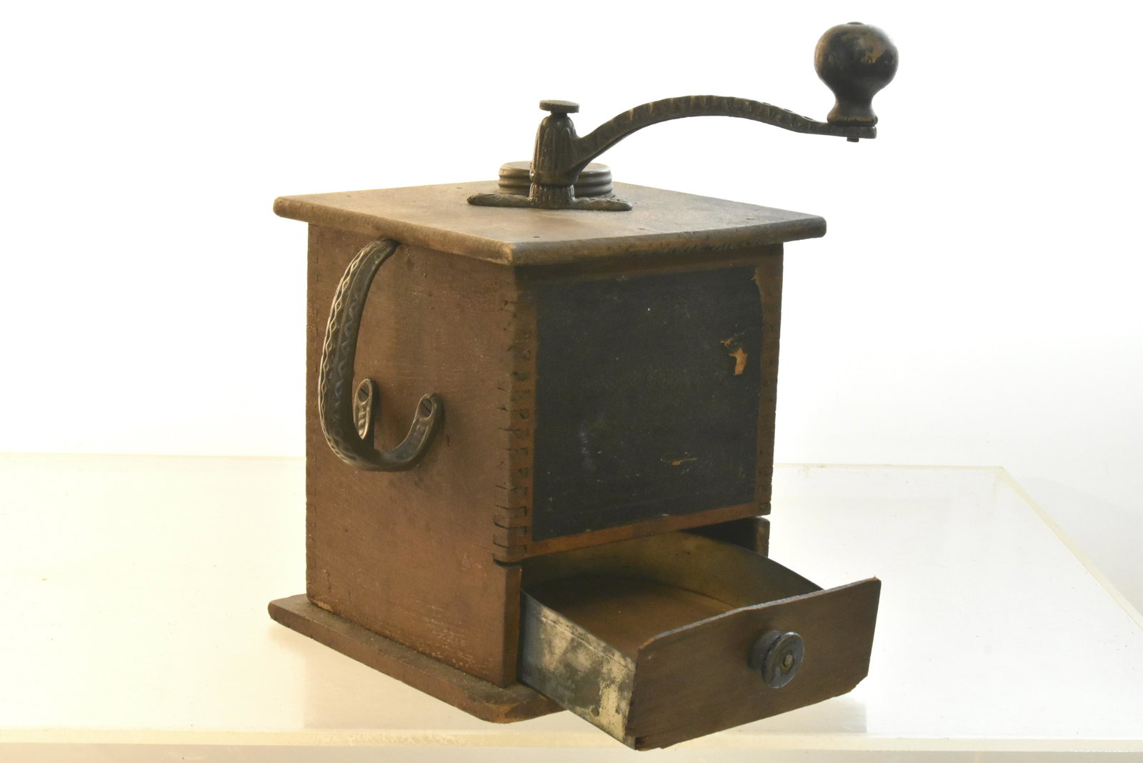 19th C Coffee Grinder: Item measures approximately 11"H to top of handle. It has a finger jointed case with cast iron hardware, and a darkened original label. Item also has some loss to drawer face, and it appears to be fun
