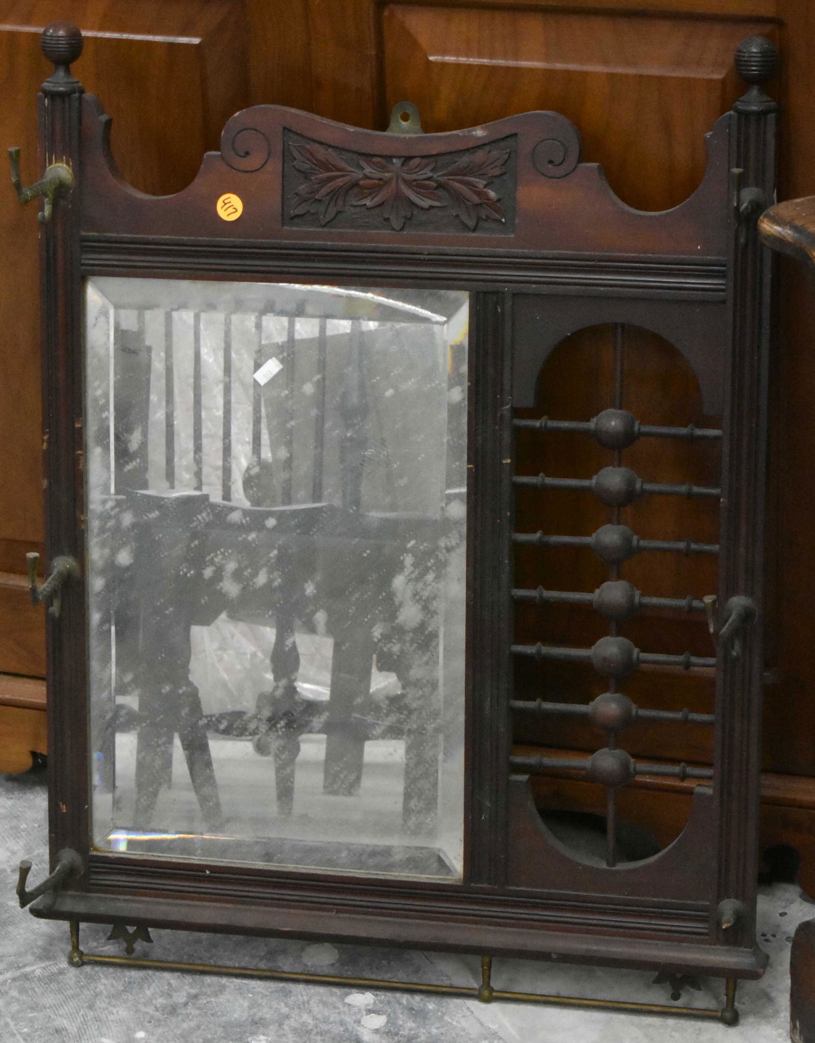 Victorian Stick and Ball Coat Rack: Item measures approximately 28"H x 21"W. It has (5) of its (6) original hooks, a beveled mirror, a stick and ball panel, and it is mahogany construction.