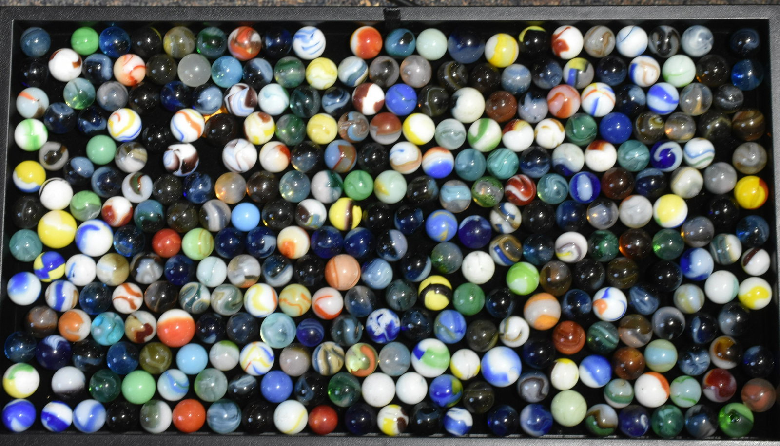 Collection of Marbles: Lot includes bumblebees, agate, cobalt, and colorful swirl marbles. Approximately (200) marbles.