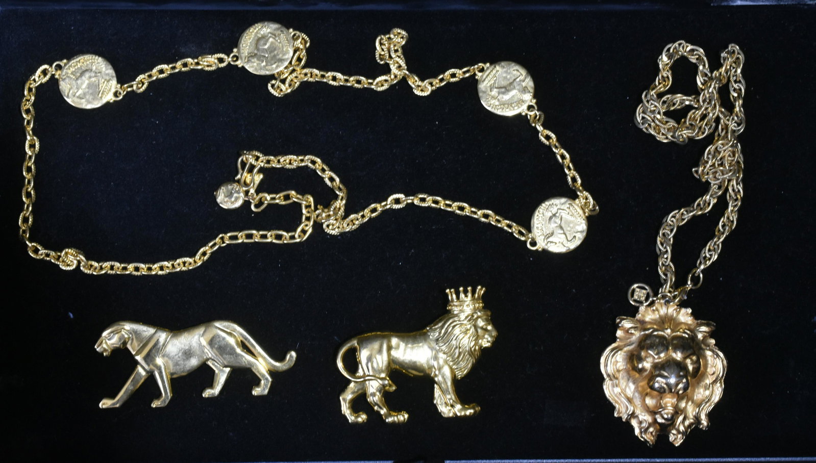 Lion and Leopard Jewelry Grouping: Lot includes necklace with large, lion head pendant, a Givenchy link necklace with four horse pendants, a lion with crown brooch, and a sleek panther brooch.