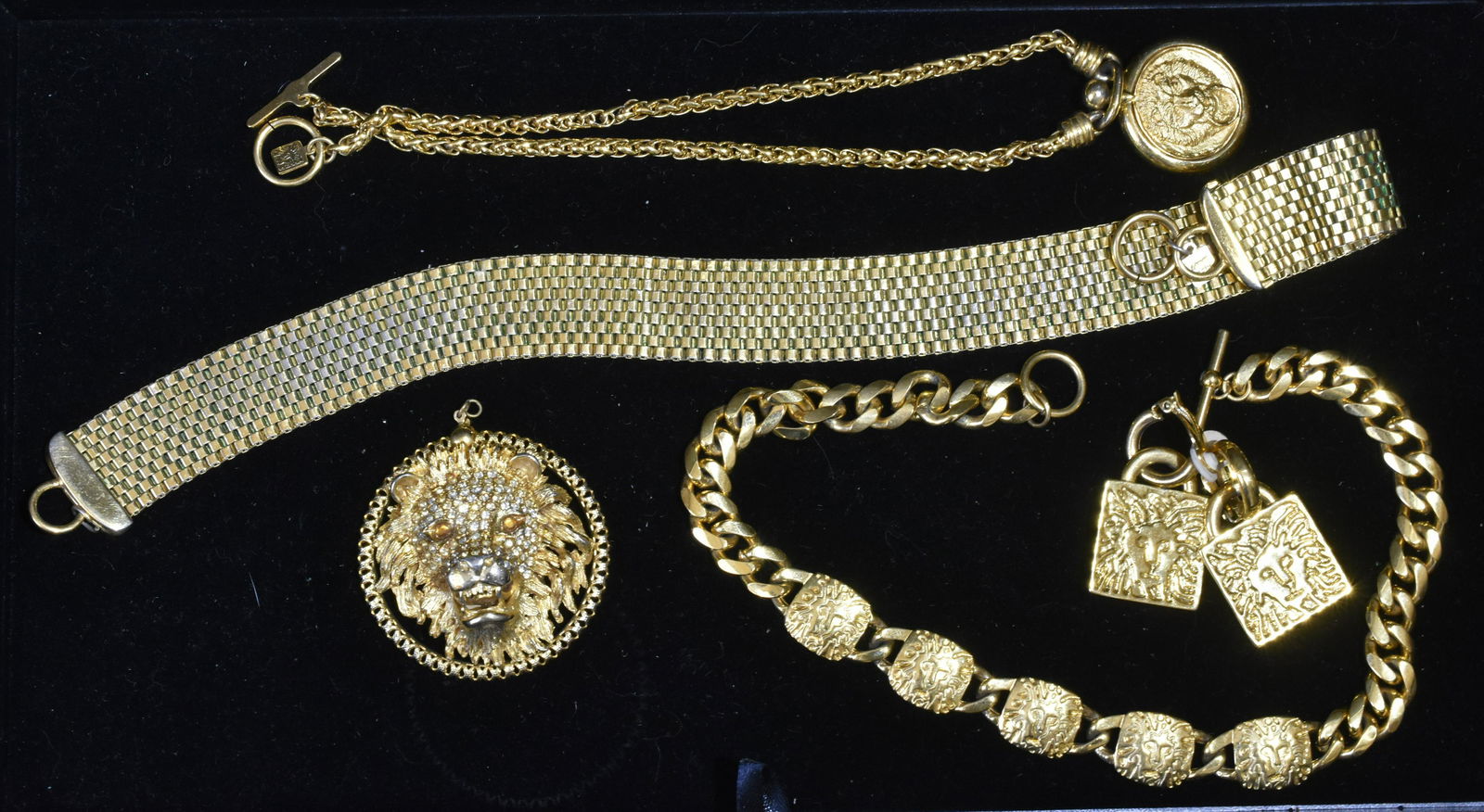 Lion Head Jewelry Grouping: Lot includes an Anne Klein necklace and earring set, a large lion head pendant with rhinestones, an Anne Klein watch fob, and a wide Anne Klein mesh necklace.
