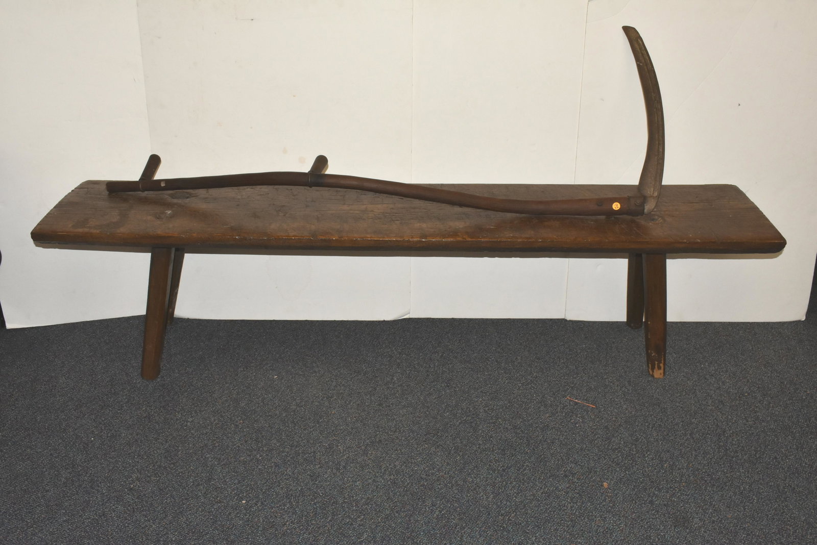 Mortise Bench and a Scythe: Bench measures 19"H x 77"L, and it has a single plank top with mortise through legs. Lot also includes a wooden handle scythe.