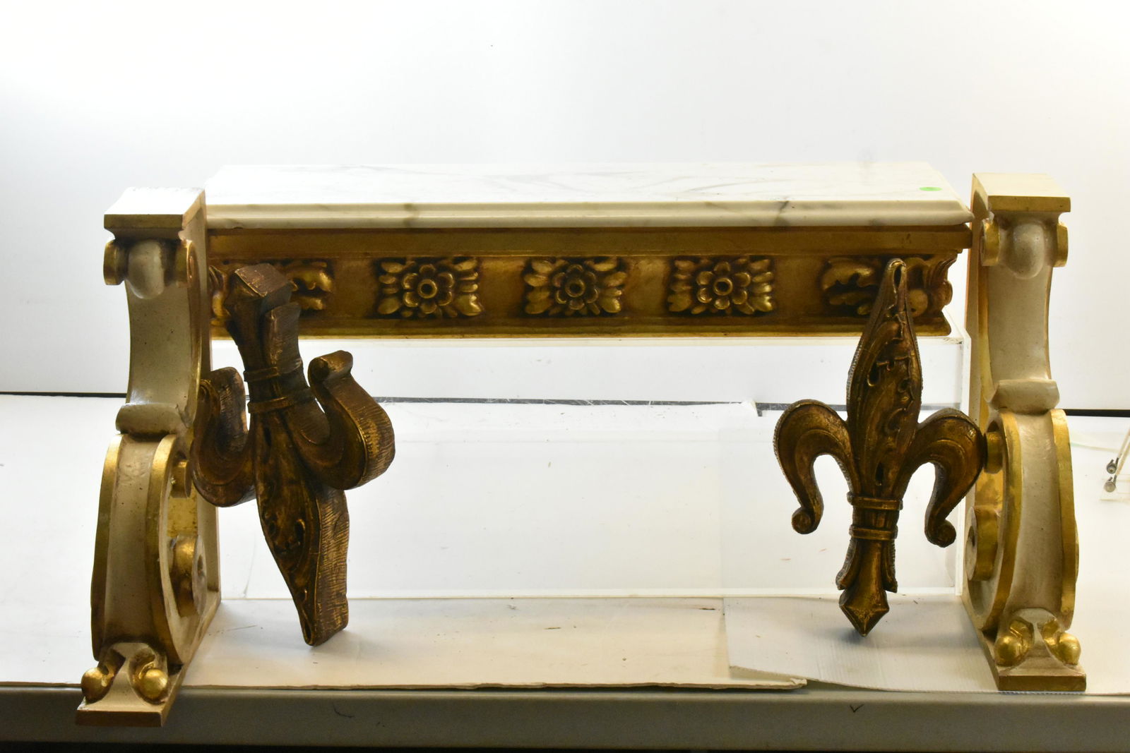 Mixed Decorative Grouping: Lot includes a marble top shelf measuring 5"H x 27"L x 8"D. Marble has a small chip on one corner. Lot also includes (2) large shelf brackets and (2) fleur de lis.
