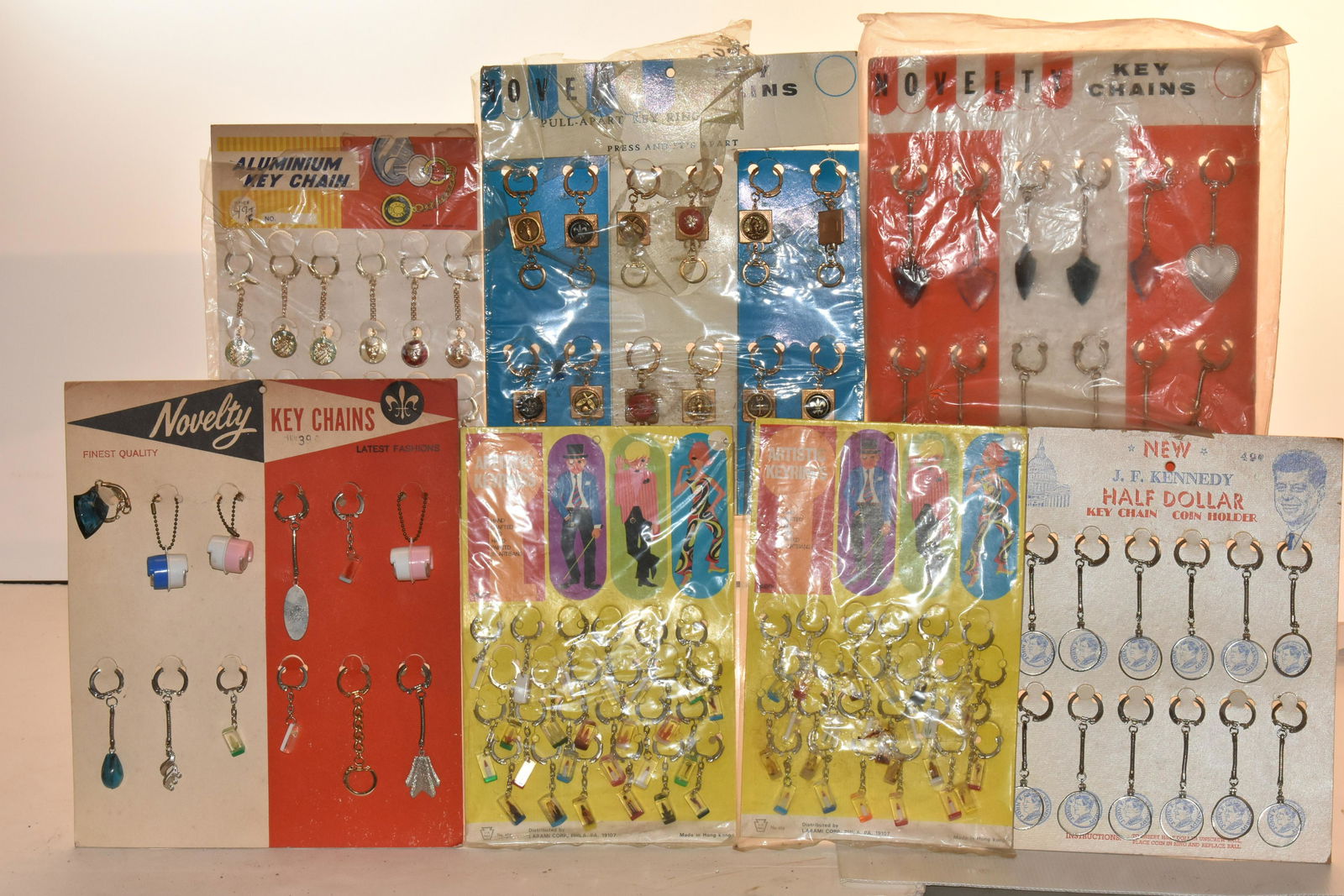 Collection of Novelty Key Chains: Lot includes (2) packs of artistic key chains from the 1970's, Kennedy half dollar key chain holders, decorative novelty key chains, and key chains with coin holders.