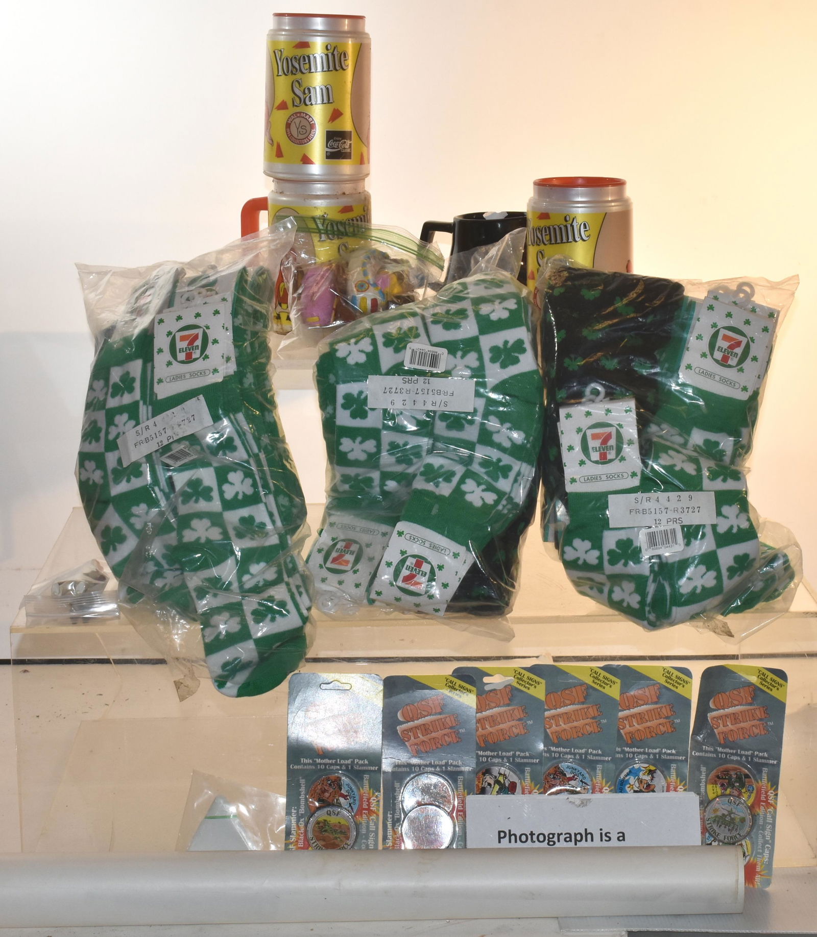 QSF Straight Force Caps and Socks: Lot includes a large selection of Straight Force Motherload packs, a large selection of men's St. Patrick's Day socks, (3) Yosemite Sam mugs with lids, and other miscellaneous items.