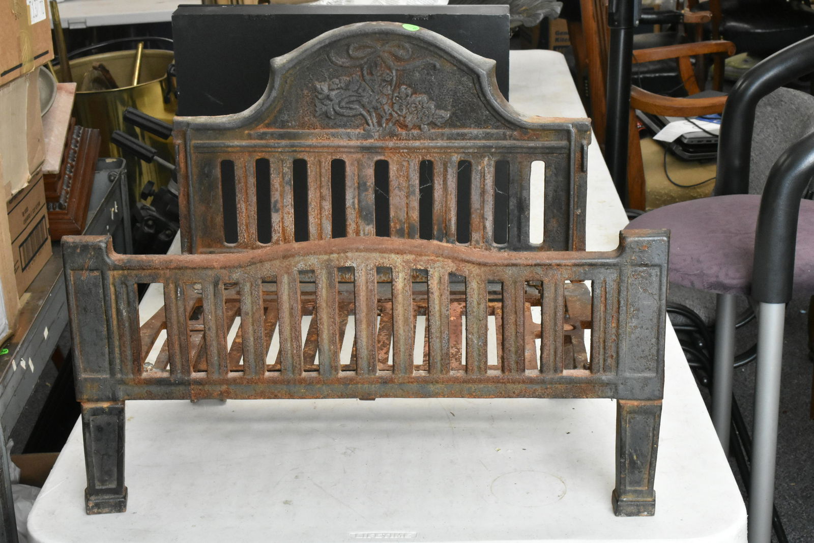 Vintage Fireplace Insert: Fireplace log carrier insert with floral motif on headboard.