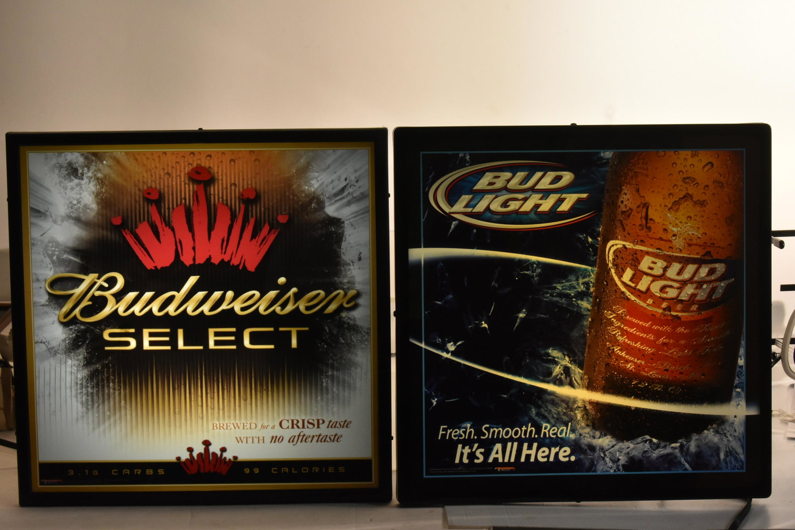 (2) Budweiser Lighted Advertising Signs: Both items measures approximately 18"H x 18"W. The first is Budweiser Select, the second is Bud Light, and they are both new in plastic wrapping.