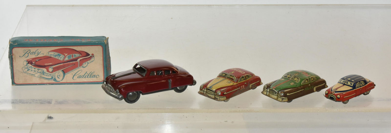 Vintage Tin Friction Vehicles: Lot includes a Baby Cadillac in box and is delicately used. Item was produced by SSS Japan. Lot also includes (3) small friction toys that no longer function.