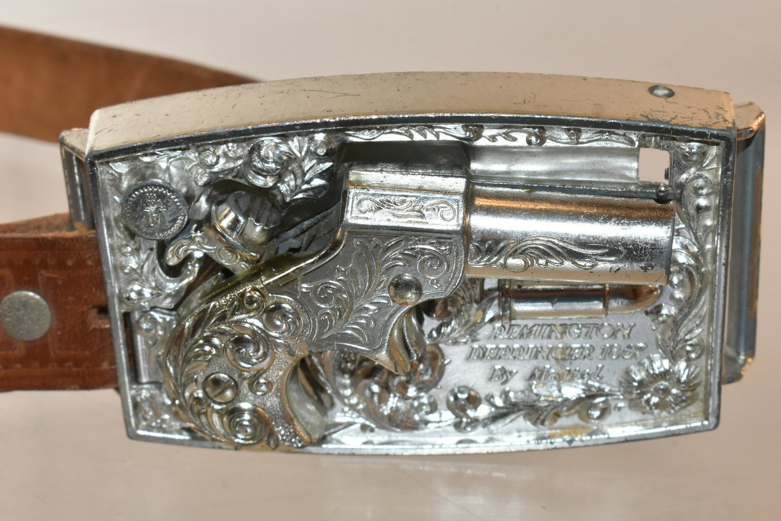Mattel Derringer Belt and Buckle: Buckle measures approximately 4"L. It contains a Derringer pistol that mechanically pops out by a switch. The pistol is a cap gun, and the cap mechanism functions. It comes with a leather belt. Belt h