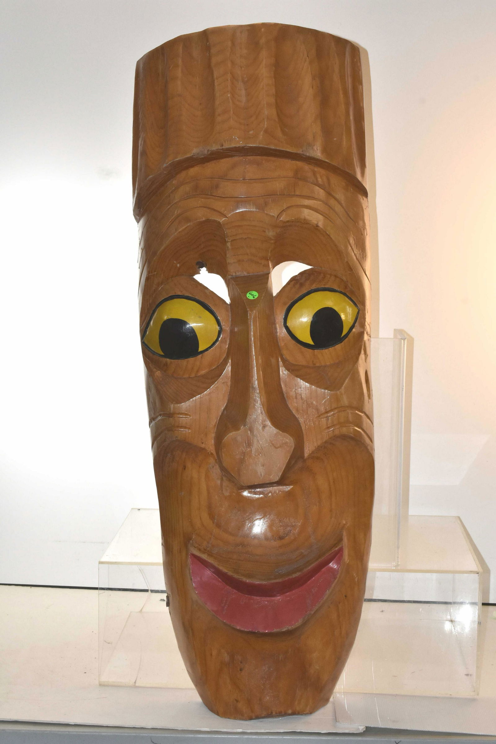 Carved Tiki Head from Rummy's Tavern: Item measures approximately 48"H x 16"W. It is carved from a single piece of wood. It has original hand painted eyes and mouth, and shows some loss above right eye, below a wood knot.
