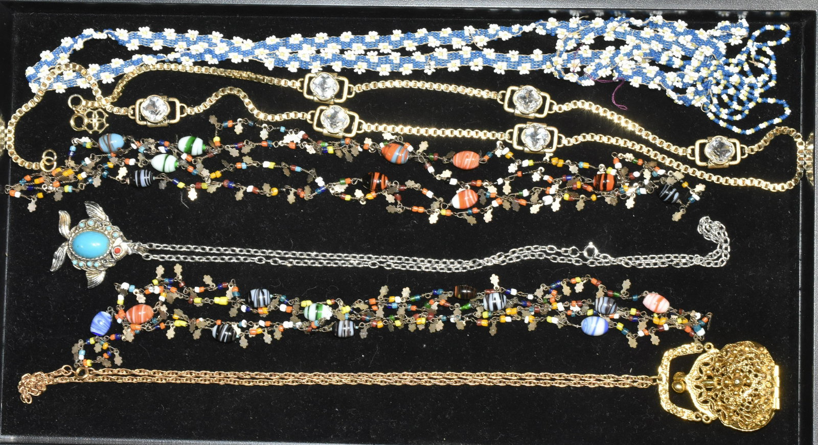 Vintage Necklace Grouping (2 Trays): Lot includes amber style necklace, lucite necklace with geometric pendant, gold tone necklace with large crystals, necklace with pocketbook locket, and other necklaces.