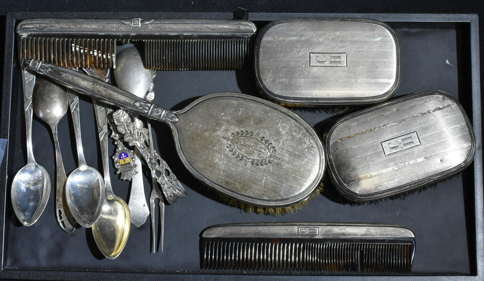 Grouping of Sterling and .800 Silver: Lot includes a (5) piece sterling vanity set (both combs missing teeth), (6) spoons (some are sterling, some are .800 silver), an .835 silver olive fork, and a pair of silver tongs.