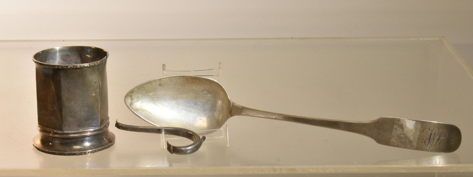 19th C Coin Silver Grouping: Lot includes a Robert Wilson New York and Philadelphia strainer spoon circa 1820, measuring approximately 11.5"L. Lot also includes a Robert Wilson child's cup with detached handle, approximately 7.5