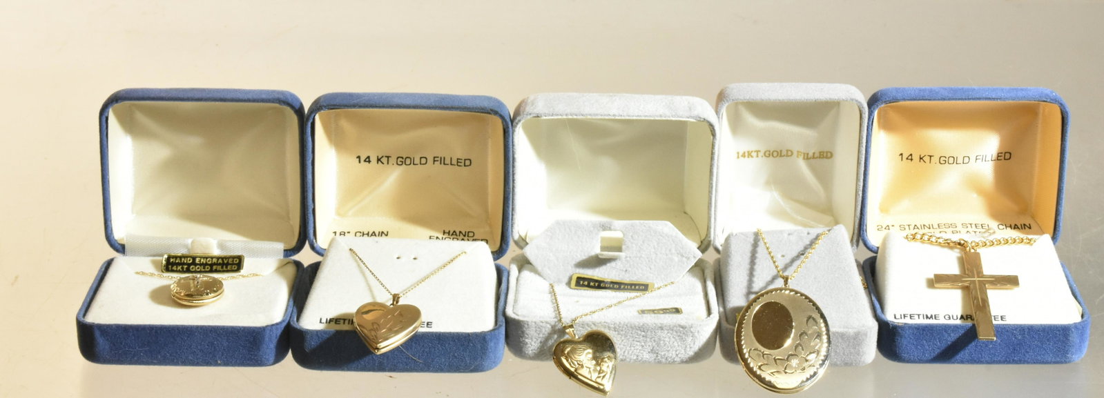 14K Gold Filled Lockets NIB: Lot includes (4) hand engraved 14K gold filled lockets and a cross, all in original boxes and chain.