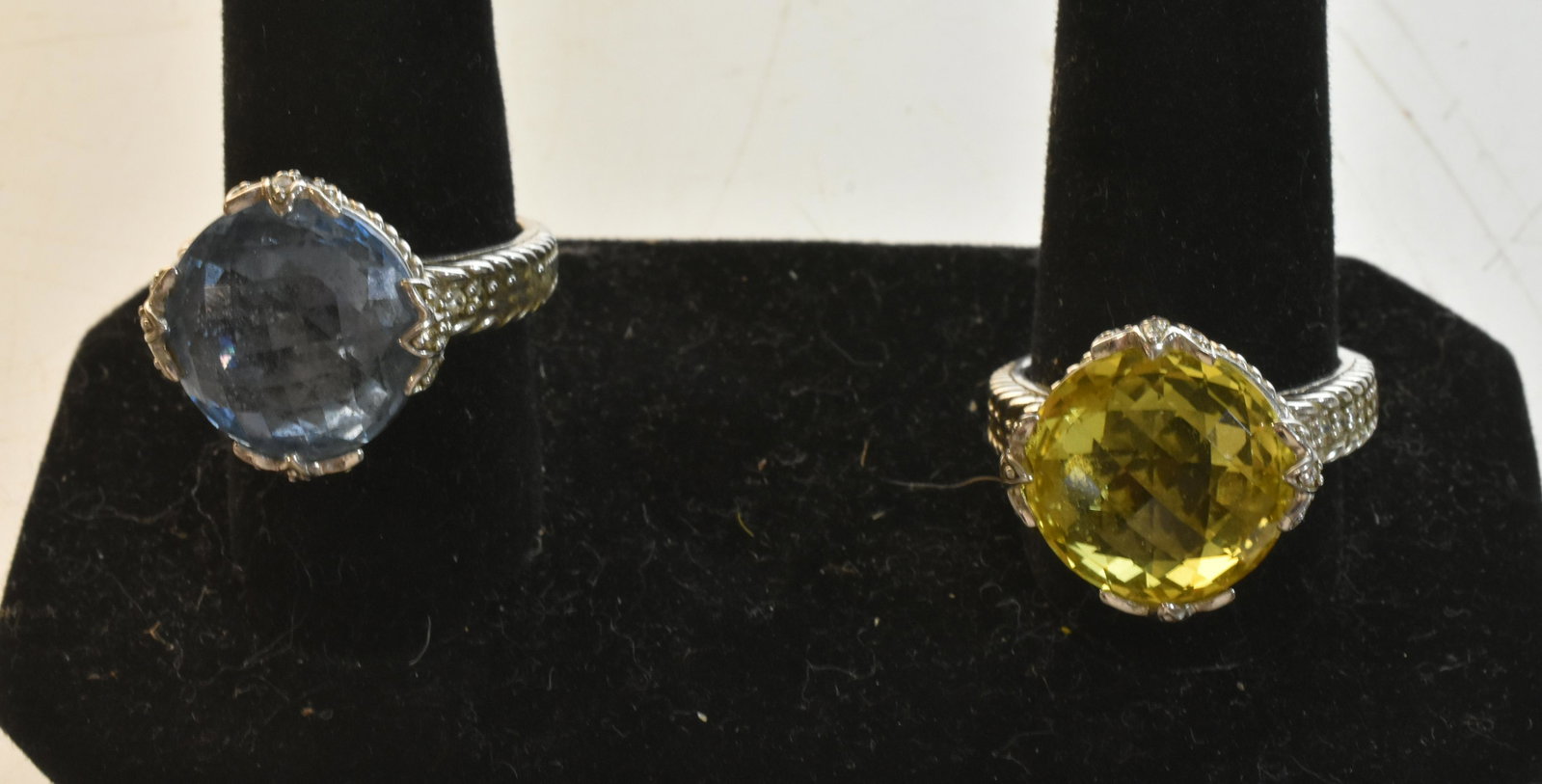Pair of Judith Ripka Sterling Rings: One of the rings has a heavily faceted blue stone, while the other has a heavily faceted yellow stone. Both are marked Judith Ripka .925.