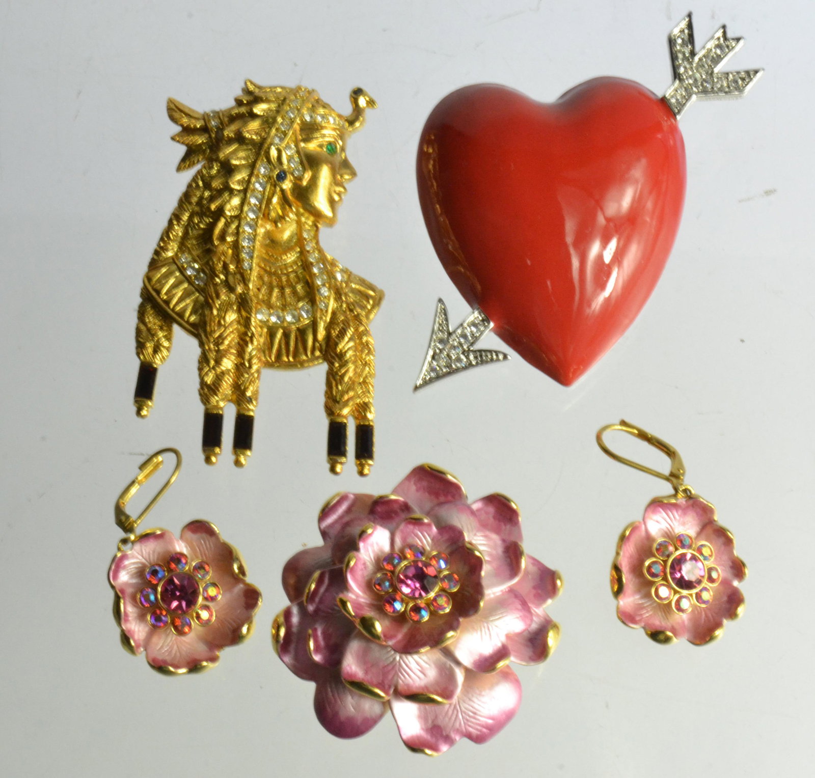 Vintage Bob Mackie and Joan Rivers Jewelry: Lot includes a large Bob Mackie heart brooch with crystals, a Bob Mackie Egyptian style brooch, with clear and red rhinestones, and a floral Joan Rivers brooch and earring set with colorful rhinestone