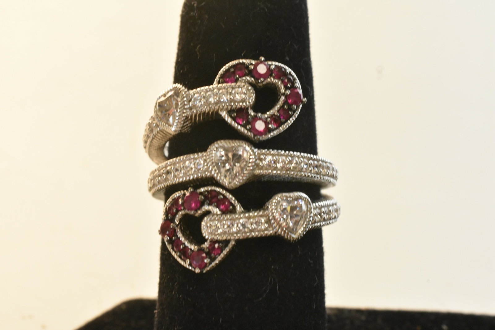 Designer Judith Ripka Sterling Ring: Signed Judith Ripka sterling silver triple band ring, with CZ and red stone heart design.