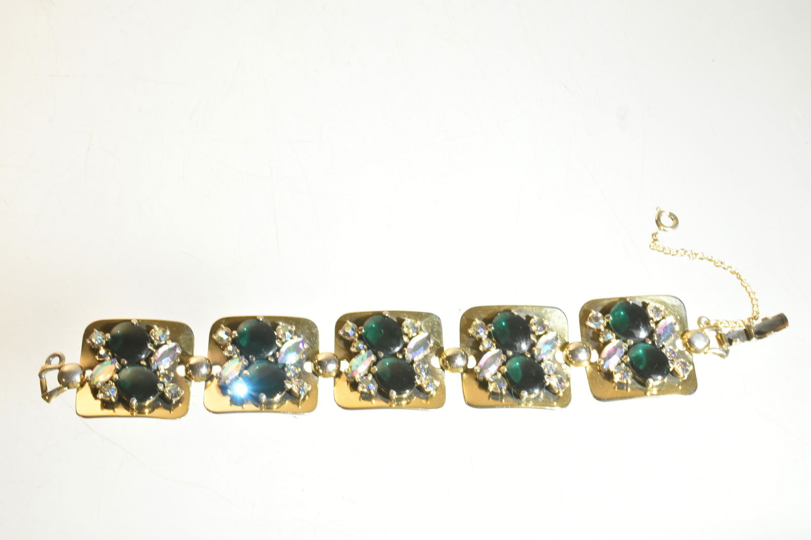 Vintage Elsa Schiaparelli Bracelet: Item is a large, heavily jeweled panels bracelet with cabochon green stones and aurora borealis. Item is signed on clasp, and dates to the 1930's-1940's.