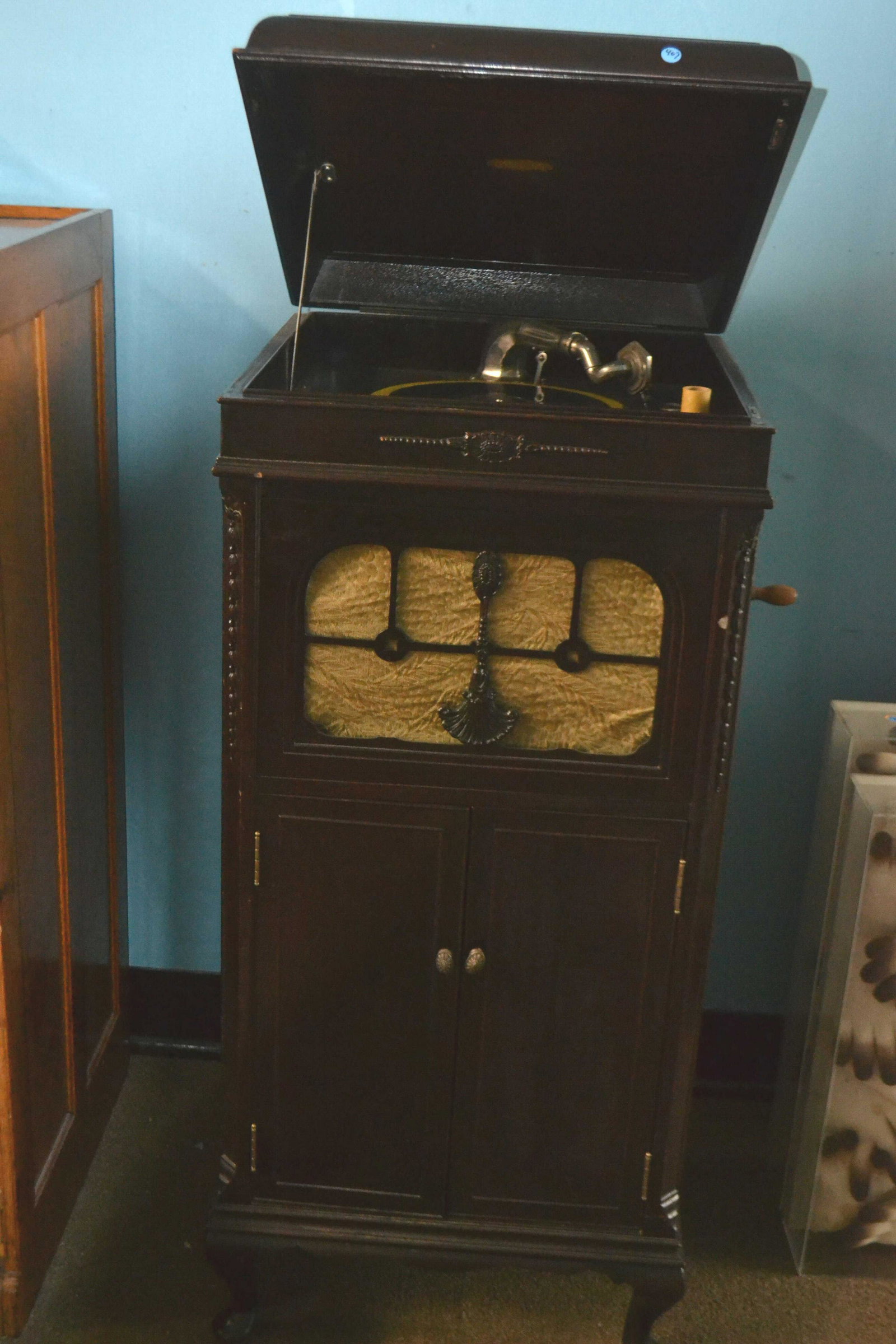 Partiste Victrola in Mahogany Case: Item measures approximately 49"h x 22"W x 22"D. It has a decorative front, stands on Queen Anne feet, and it is currently non functioning.
