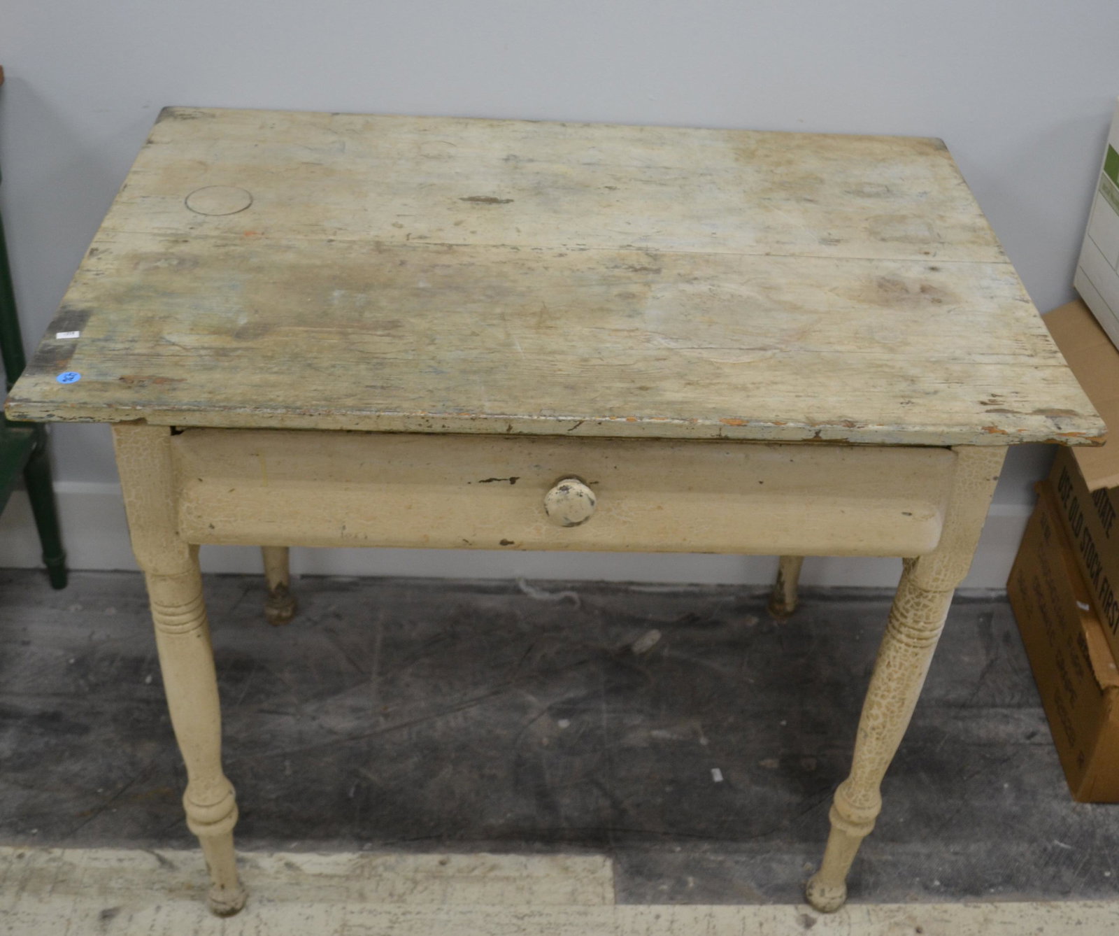 Country Farm Table with a Drawer: Item measures approximately 28"H x 36"W x 24"D. It is a softwood table with a two board top, a hand dove tailed drawer, old white paint, and stand on a well turned leg.