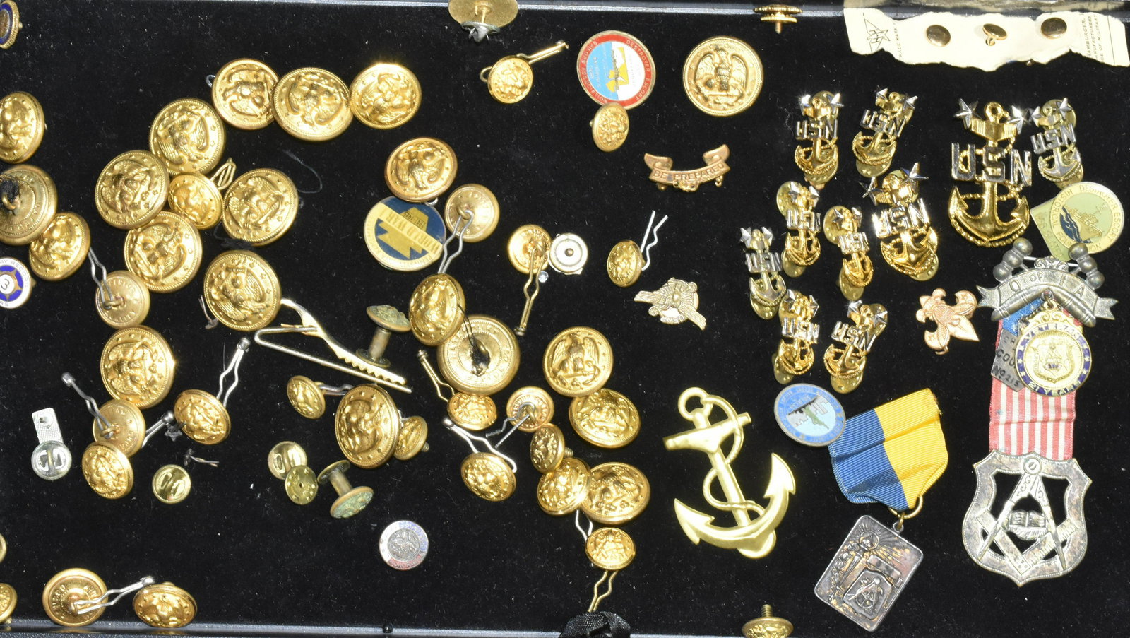 Military Buttons and Insignias: Lot includes a large selection of military buttons, US Navy insignias, an Oath of IA Masonic medal with ribbon, Masonic award with ribbon, and various enameled lapel pins.