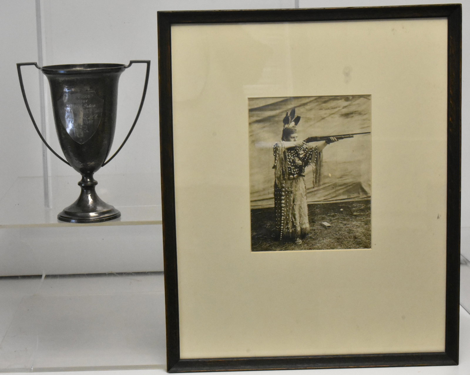 Annie Oakley Day Marksmanship Trophy 1917: Trophy measures approximately 9"H. Inscription reads "First Place Amateur Ms. Nell Peters, Annie Oakley Day, Pinehurst, NC Feb. 11. 1917 U.M.C. Co". Trophy appears to retain original patina, has a sli
