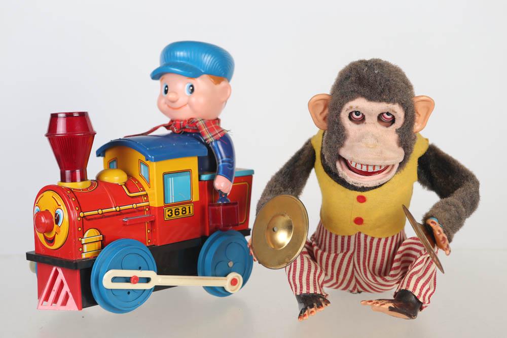 Battery Operated Monkey and Locomotive: Lot includes a vintage cymbal playing monkey made by CK Japan. Clean battery box. Clip is missing. Monkey shows wear to lower lip. Lot also includes Japanese tin litho and plastic battery operated tra