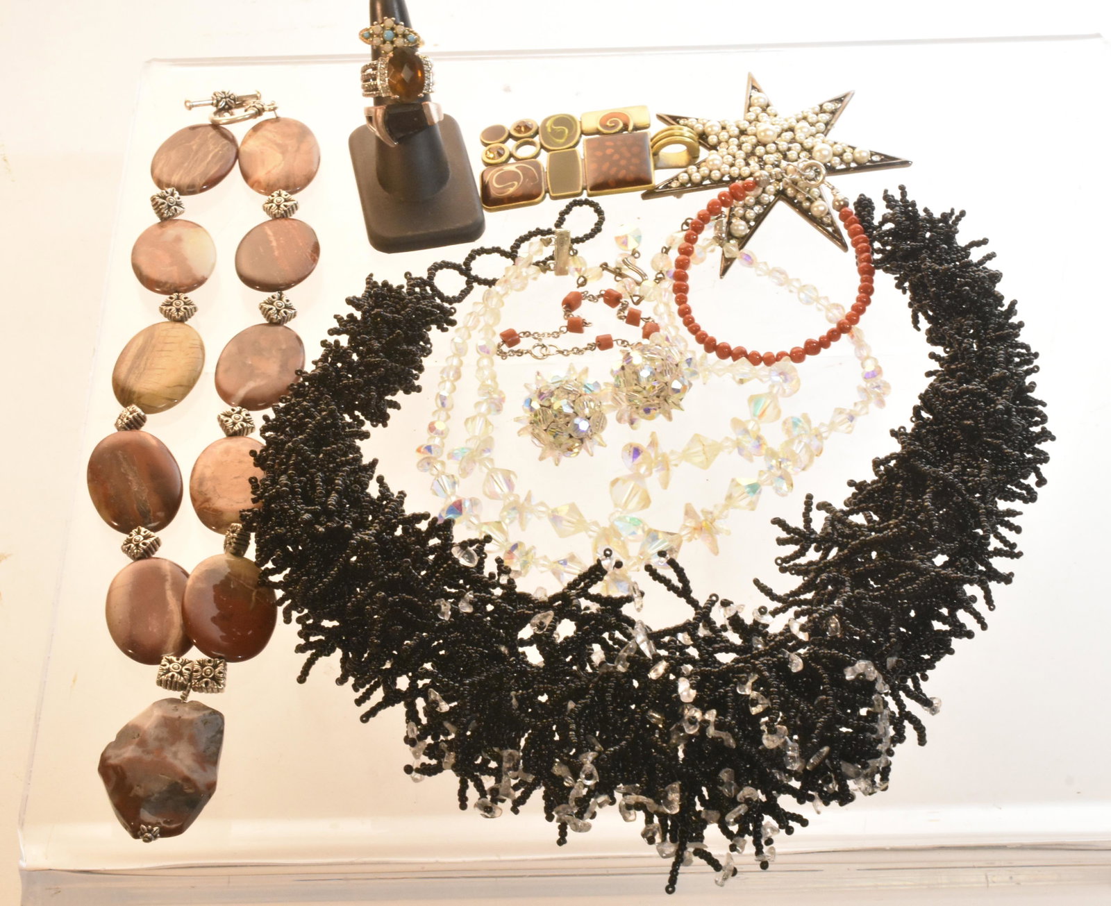 Quality Estate Jewelry: Lot includes large statement necklaces (including stone , black bead, and aurora borealis), large star brooch, and (2) sterling and red coral bracelets.