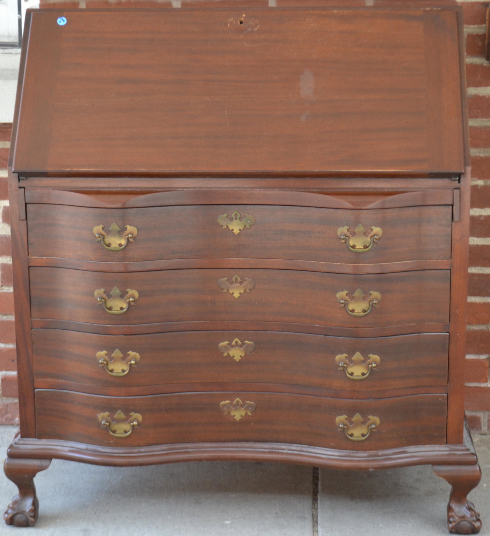 Maddox Mahogany Drop Front Desk: Item measures approximately 42"H x 46"W x 21"D. It is solid mahogany construction with an oxbow front, claw and ball feet, and an escutcheon is loss from desktop.