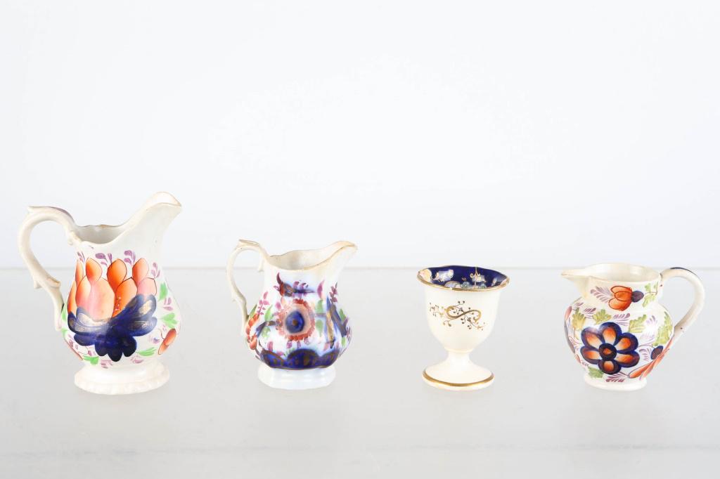Gaudy Welsh Cream Pitchers and Egg Cup: Largest cream pitcher approximately 4.5"H. Early grape pattern. Lot also includes (2) cream pitchers with floral patterns, and an egg cup with gold decoration on exterior and floral pattern on interio