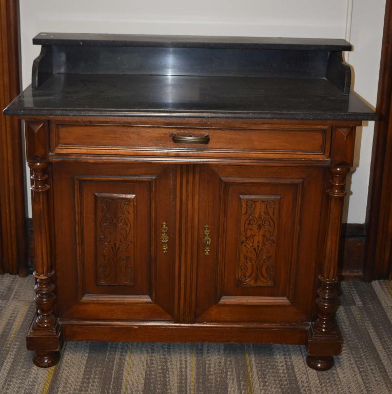 High Style Victorian Marble Top Hotel Wash Stand: Approximately 38"H x 42"W x 21"D. Black marble top with gallery and shelf. Marble is undamaged. Walnut body. Hand dove tailed drawer. (2) decorative doors with original lock and key. Pillared front (o