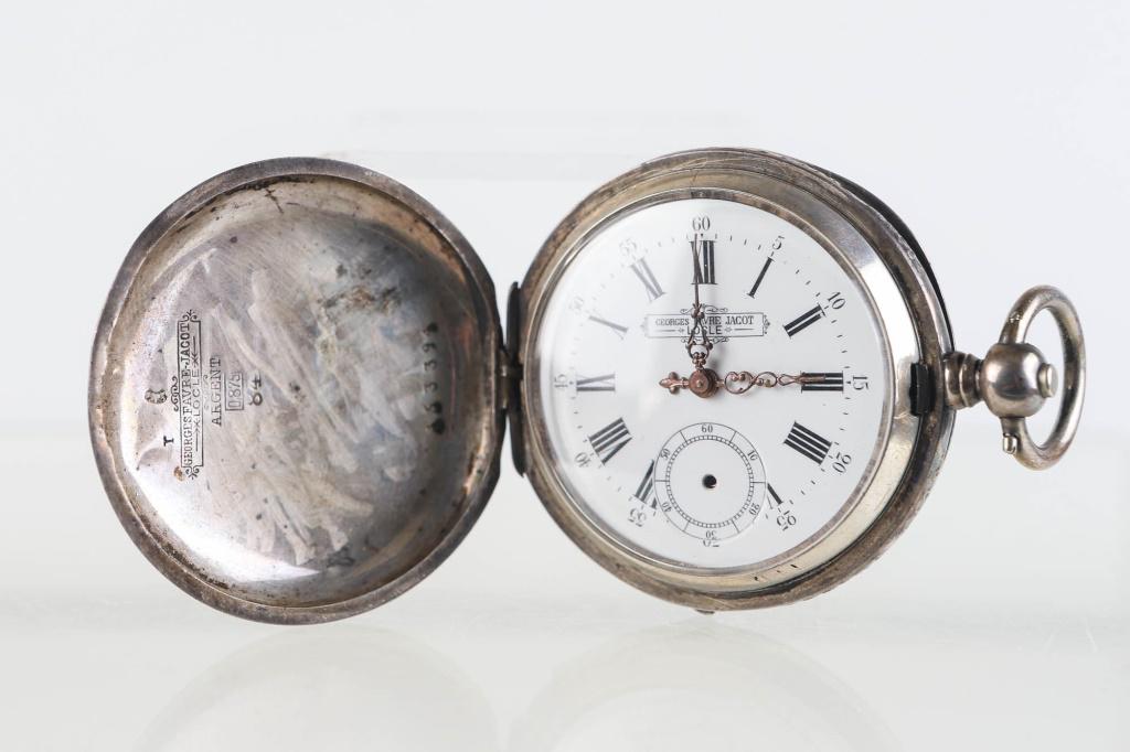 Georges Favre Jacot Key Wind Pocket Watch: Item measures approximately 2" in diameter. Face reads Georges Favre Jacot Locle. Watch is in an embossed hunt case with company logo and the word Argent 0875 - 84. (Argent is silver in French). Item