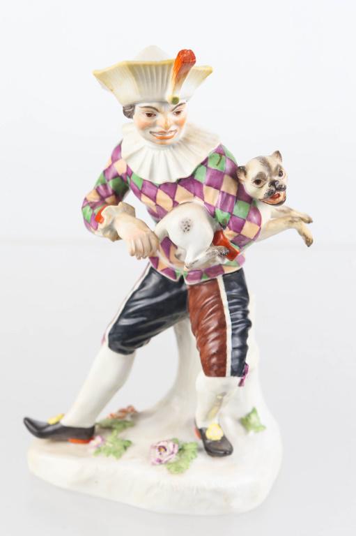 Meissen Clown with Pug Dog Figure: Figure measures approximately 7"H. It depicts a clown pulling a pug dogs tail. Meissen mark. No visible flaws.