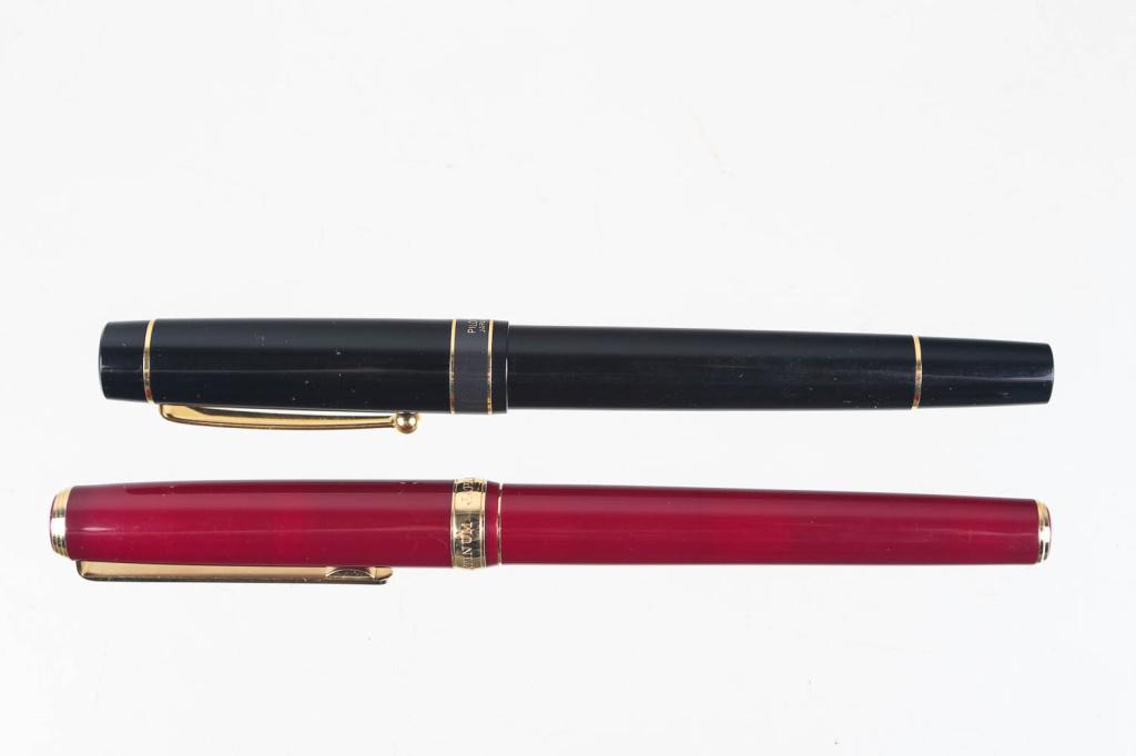 Fountain Pens Grouping: Two Japanese made fountain pens. First is a Platinum brand red pen with gold bands and clip. 22K gold dib. Second is a Pilot Egrino fountain pen, black with gold bands and clip.