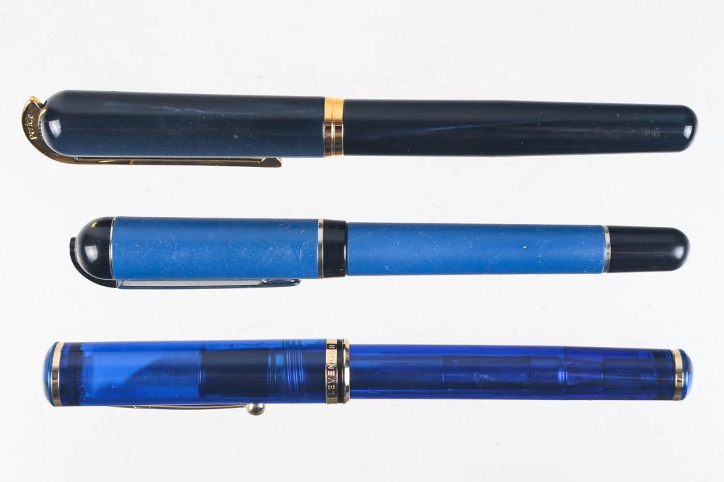Visconti, Aurora, and Sheaffer Fountain Pens: includes a Visconti Pericle blue bodied fountain pen with gold hardware and banding (nib reads Visconti Firenze M), a blue and black bodied Aurora fountain pen (nib reads M Aurora), and a Sheaffer Lev