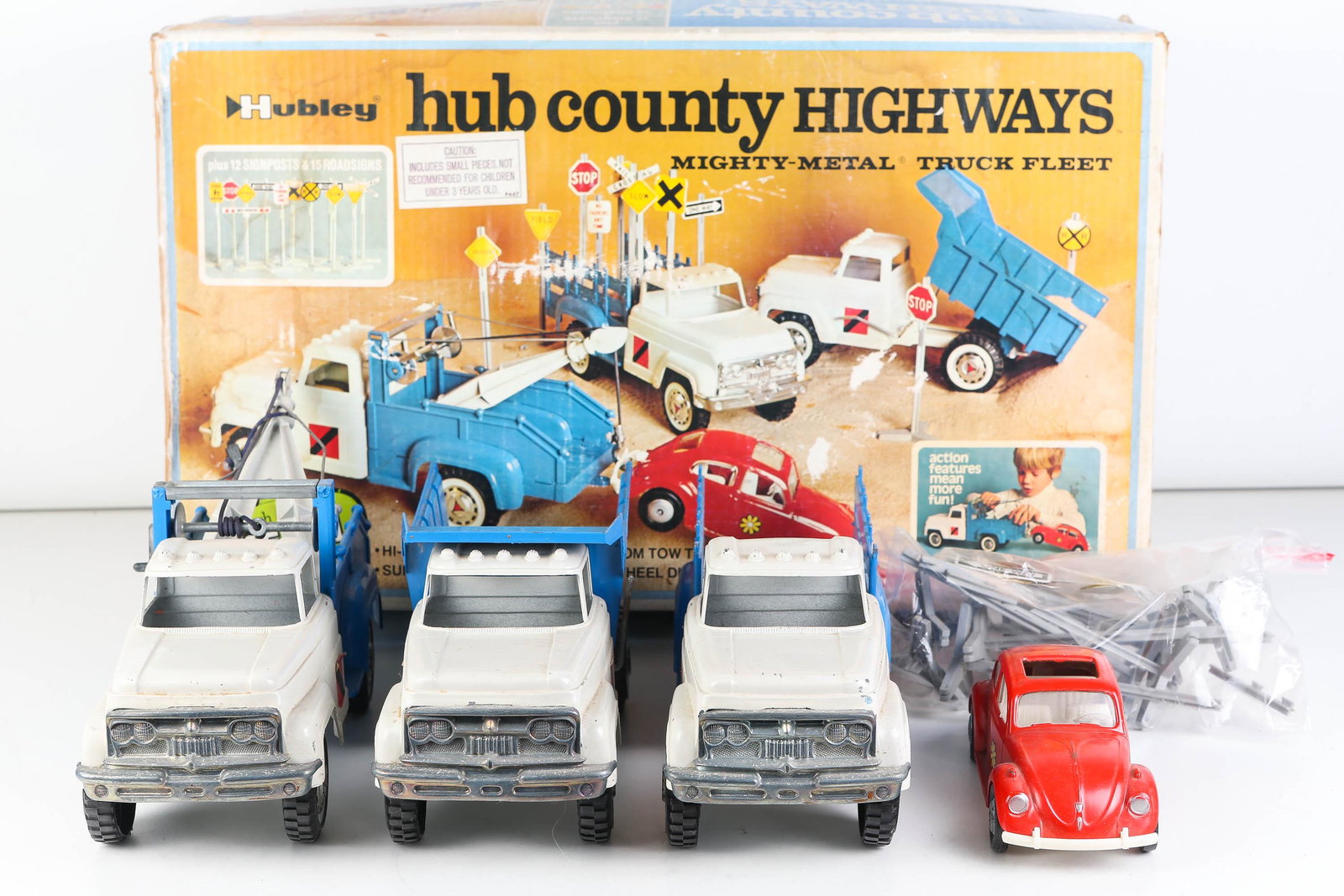 Hubley Hub County Highway Set: Set includes 4 die cast metal vehicles (sunroof beetle, tow truck, dump truck, and hi-side stake truck) trucks measure 12" long. Also includes road signs and made in 1972. Original box shows some sign
