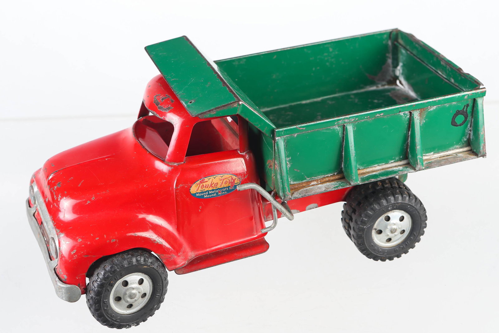 Pressed Steel Tonka Dump Truck: Truck has dual lever action for dumping, measures 13" long, with paint loss throughout body.