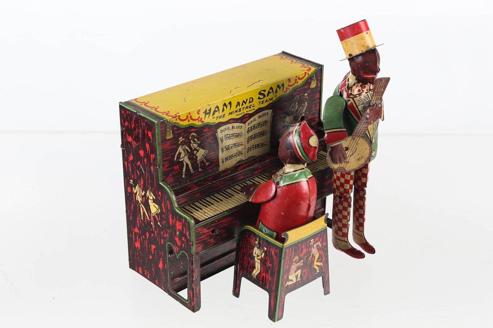 Tin Litho Ham and Sam Black Americana Toy: Toy is made by the Strauss Toys 1921. Toy is wind-up in working condition. Action features men playing instruments and dancing. Body has some scratching consistent with age.
