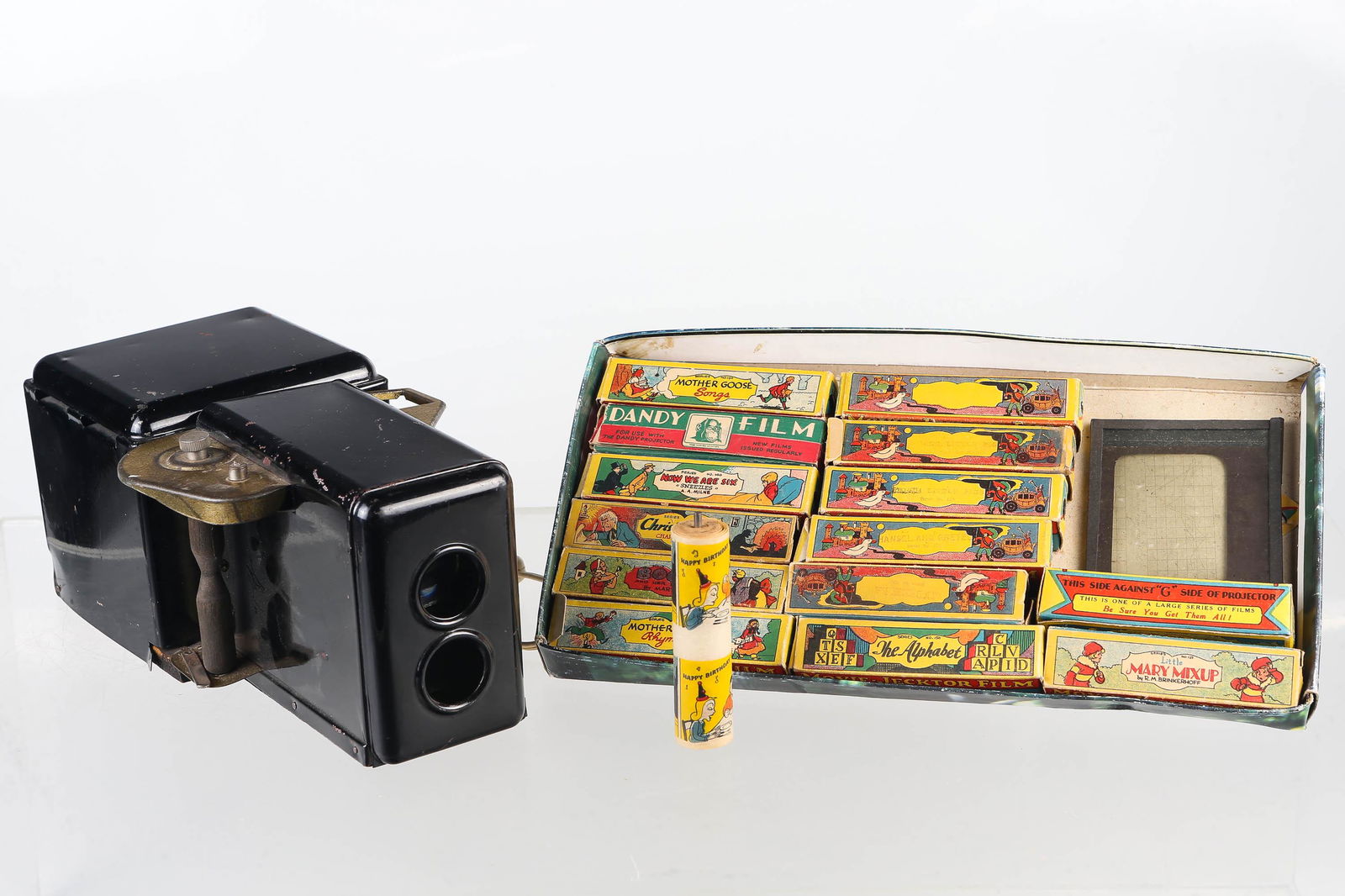 Movie-Jecktor Projector and Boxed Movie Reels: Movie-Jektor projector has metal body and wood base and is electrified. Movie reel axel holder appears to be missing and cover for light bulb. 14 films in original boxes and 1 extra, include the class