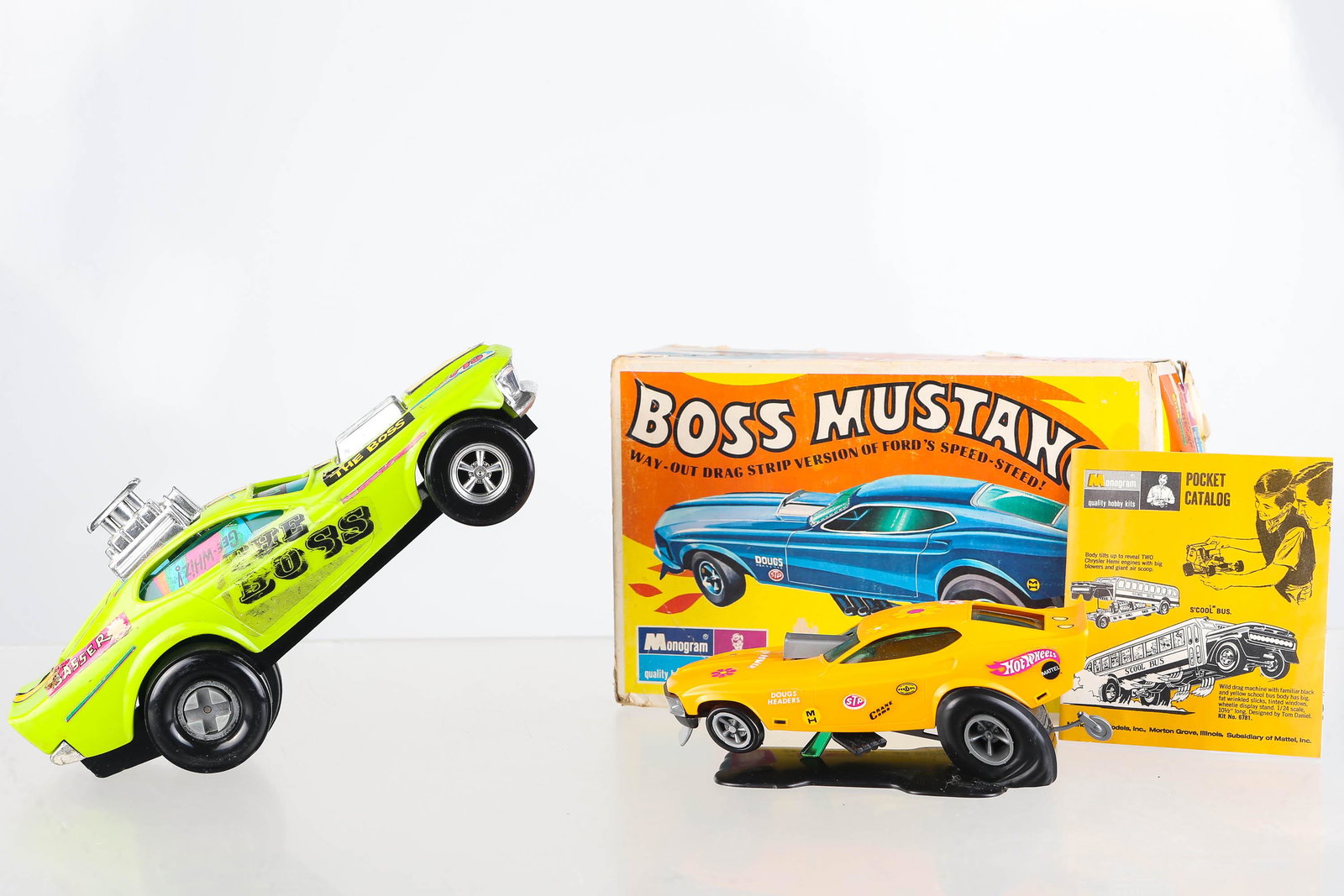 Two Boss Mustang Cars: First car is a Monogram snap tite model kit, assembled, dates from the 1970's, with assortment of decals, car is on stand, and comes with box. Second car measures 8 1/2" long, made by Hasbro, car feat