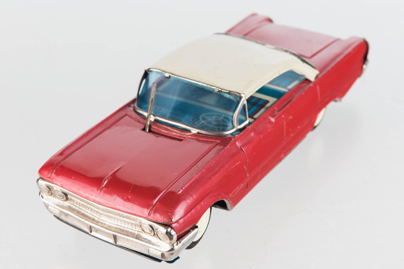 Pressed Steel Friction Powered Car: Car measures 9 1/2" long, good working friction action, and moving window wiper. Body has light scratching throughout body and no maker mark found.