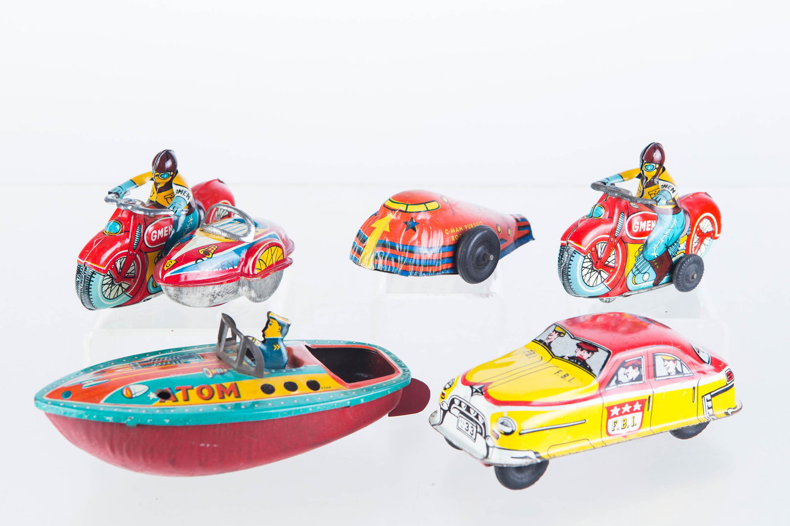 G-Man Motorcycles and Other Vehicles: Lot includes two working friction motorcycles (one with side car), both marked Japan, a Lupor FBI car with working friction, a G-Man Pursuit rocket ship (not functional), and a G-Man Atom boat.