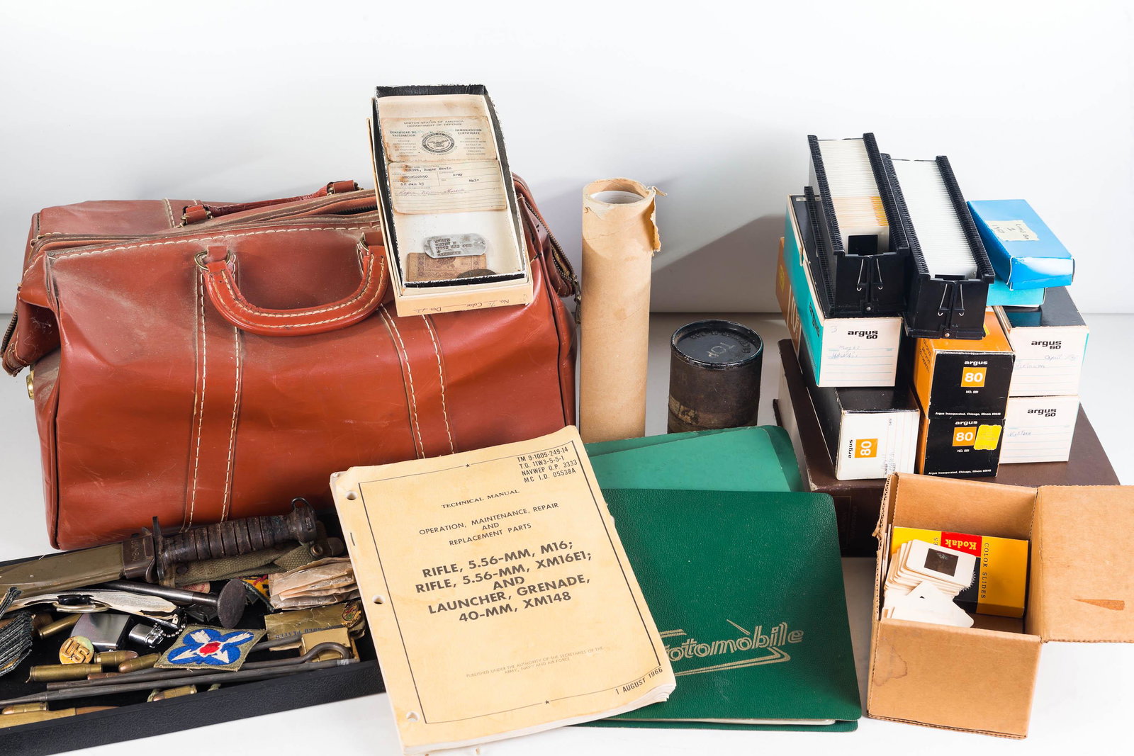 Vietnam War Assemblage Including Bayonet: Lot includes a model No USM881 bayonet with sheath, various patches, three photo albums from Vietnam War, three boxes of slides from the Vietnam War, a gun cleaning kit, M16 manual, a duffel bag, a co