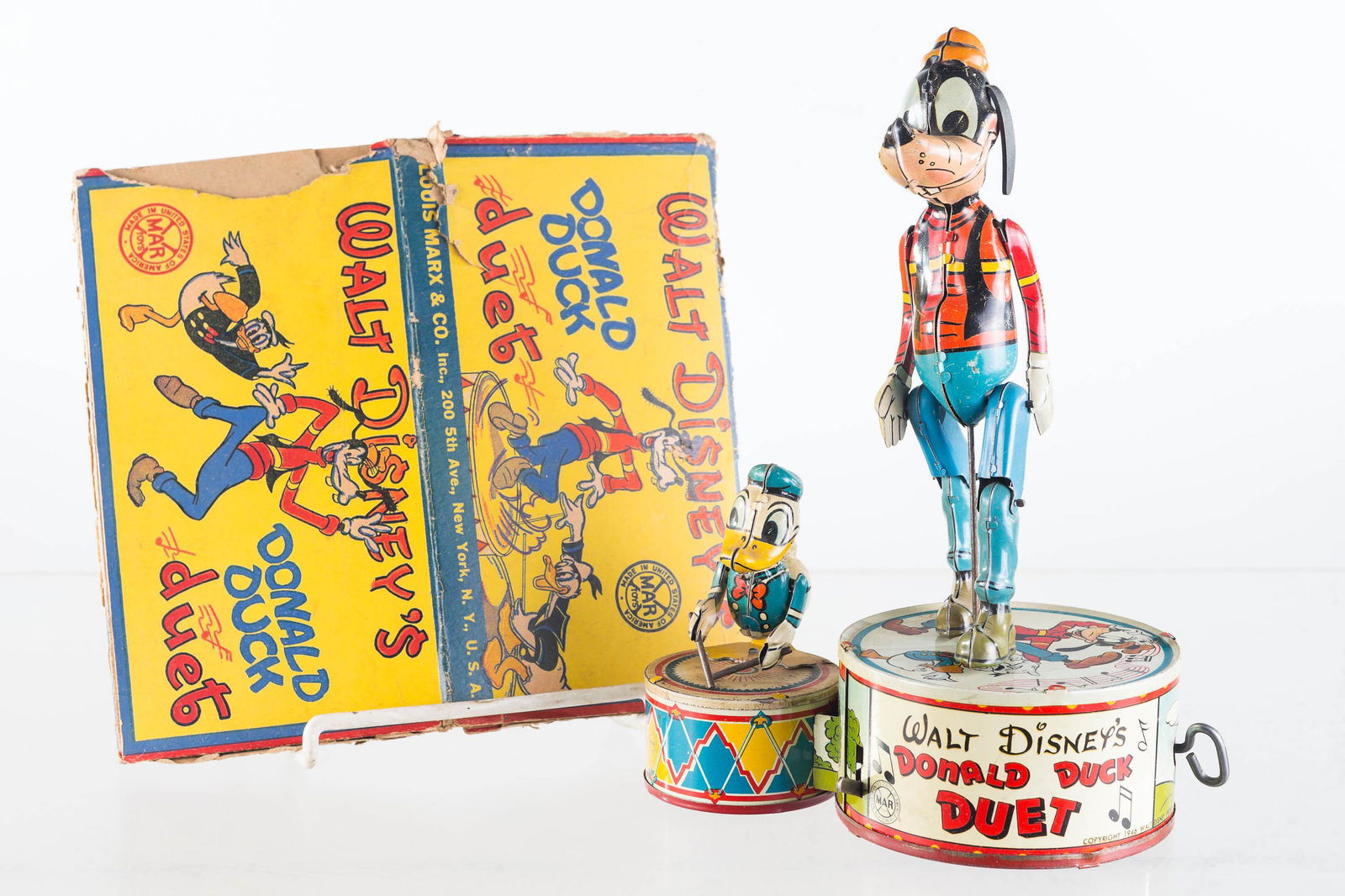 Donald Duck Duet Tin Wind Up (1946): Approximately 10.5"H. Depicts Donald Duck and Goofy. Wind up toy produced by Marx (1946). Key wind mechanism turns but toy does not function. Goofy missing one ear. Good lithography with common wear.
