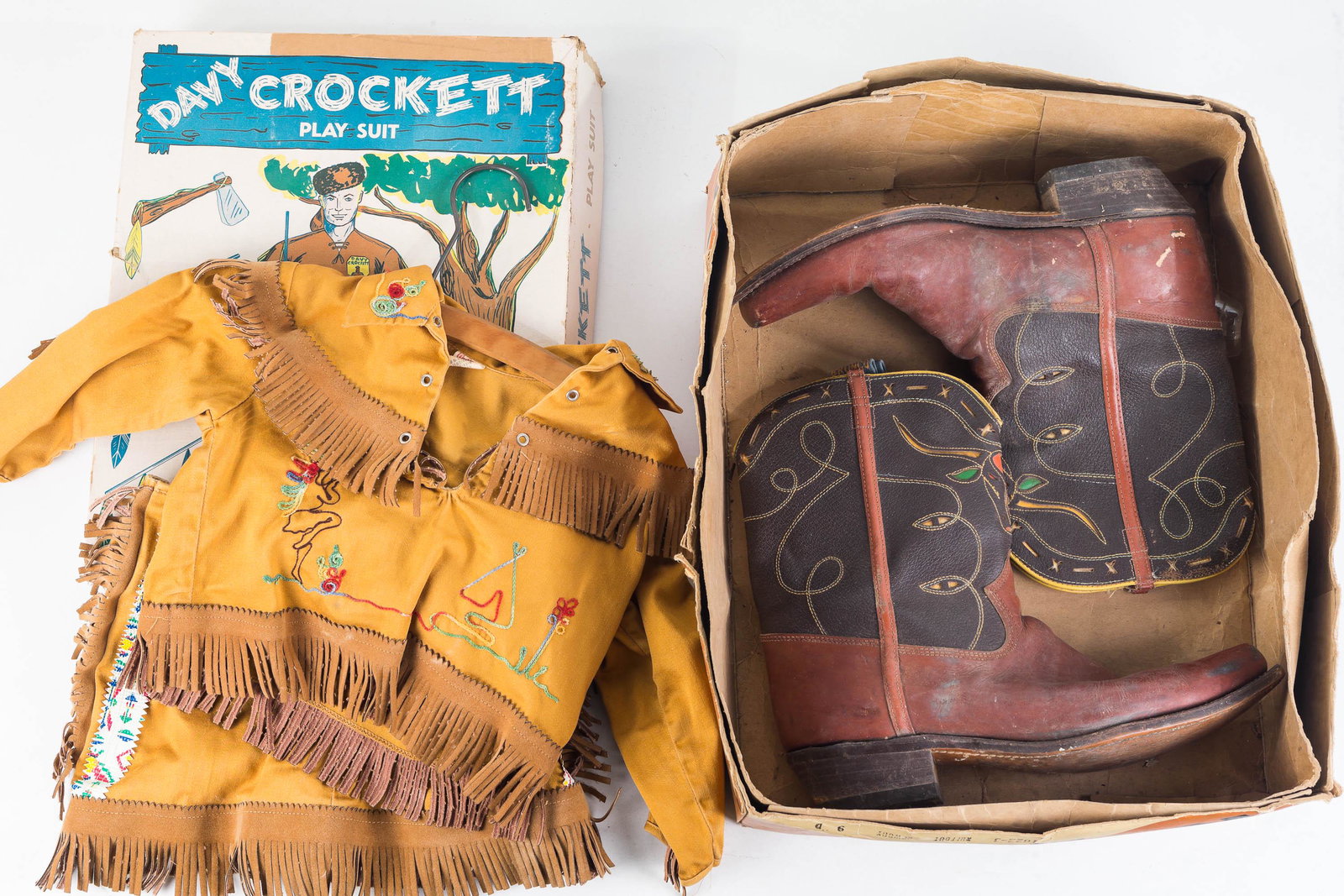 Davy Crocket Girls Play Suit and Cowboy Boots: Top is cotton with leather fringe with needlework. Tag reads Watts, Size 3. Skirt is cotton with leather fringe, with Native American attachments and matching interior tag. Both pieces are very clean.
