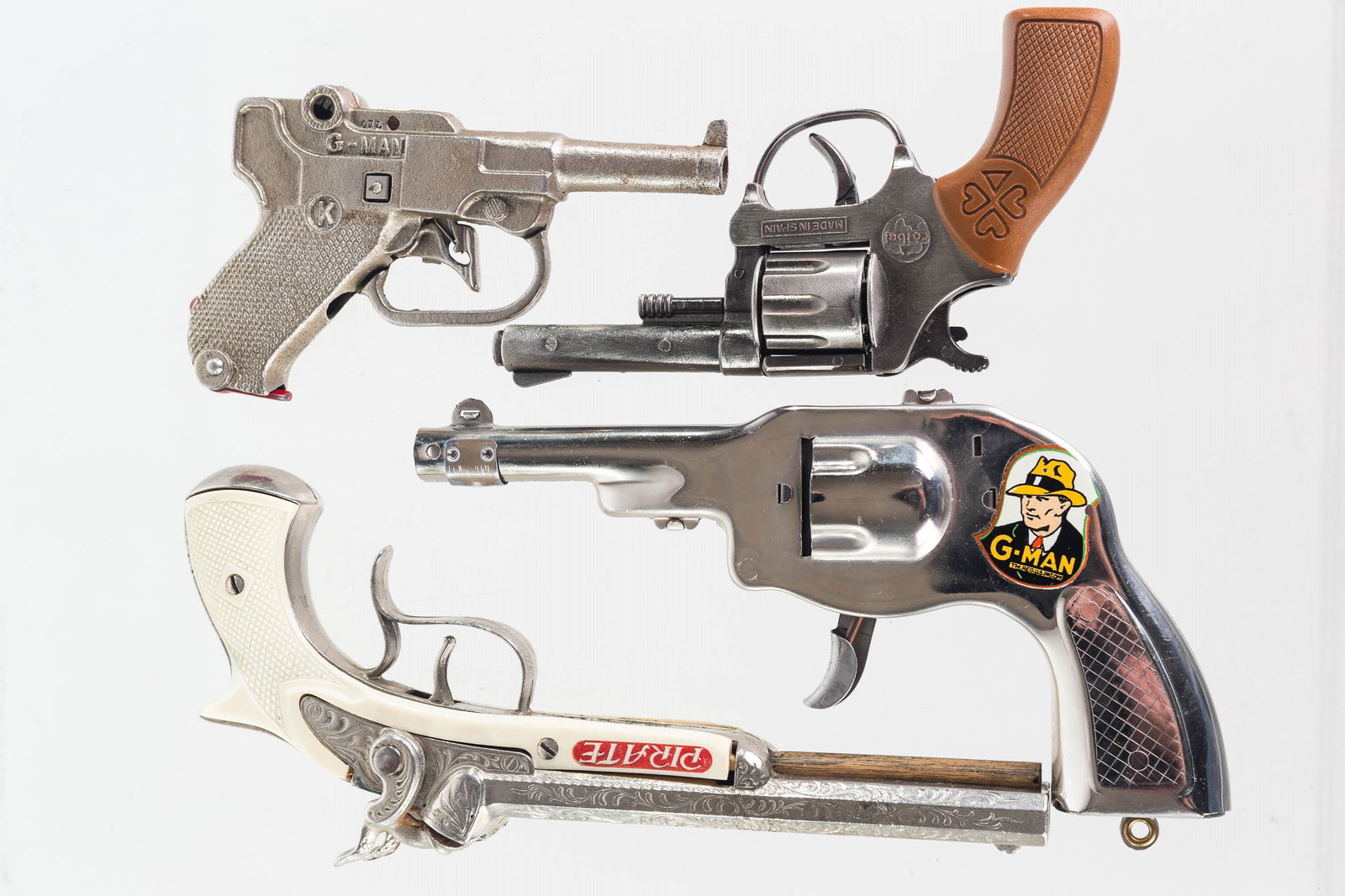 Vintage Click and Cap Pistols: Lot includes a pirate double action cap gun (clean condition, fully functional), a K Brand G-Man cap pistol (fully functional, good condition), a Spanish Coibal FBI cap pistol (functional), and a chro