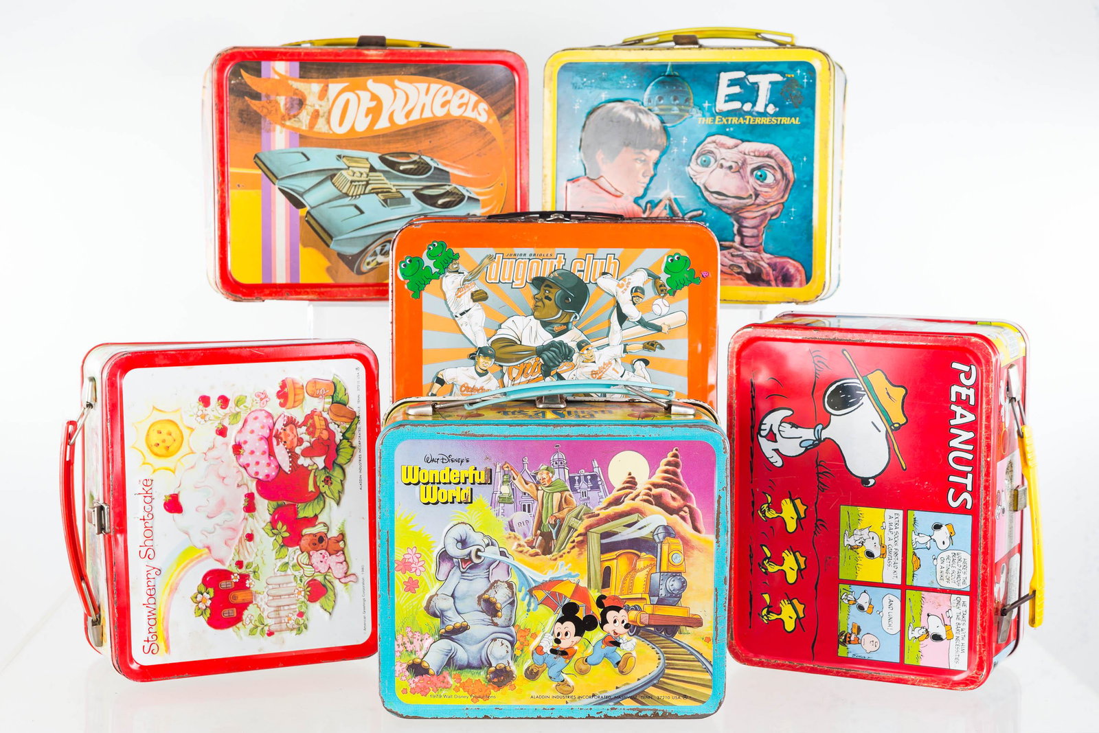Tin Lunch Boxes (6): Lot includes Peanuts with plastic thermos, ET lunch box, Baltimore Orioles Dug Out lunch box, Hot Wheels lunch box (1969), Walt Disney's Magic Kingdom lunch box (1979), and Strawberry Shortcake (1980)