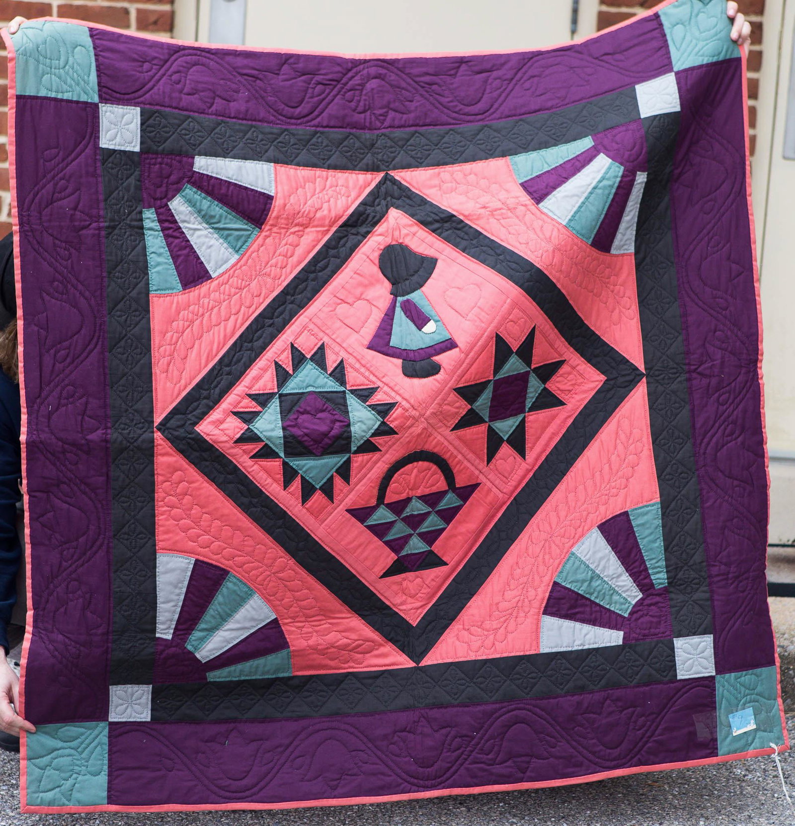 Hand Signed Amish Style Sampler Quilt: Quilt is a W. Hans stitched sampler quilt in the Amish style with applied gray heart on back reading "1987 Amish Sampler, Pieced by Helen Brilhart. Quilted by Anna Mary Charles". From the collection o